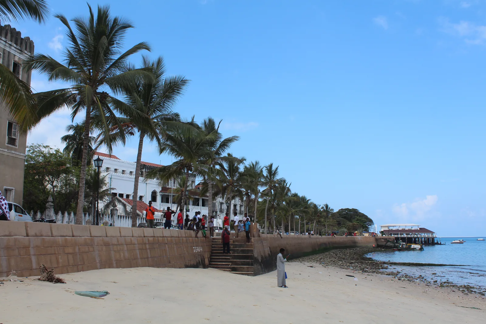 The waterfront of Stone Town in Zanzibar with old buildings and boats along the shore